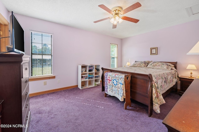 carpeted bedroom with multiple windows, a textured ceiling, and ceiling fan