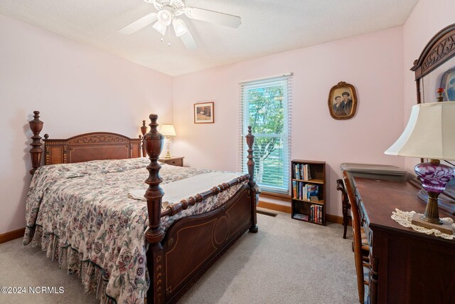 bedroom with a textured ceiling, light colored carpet, and ceiling fan