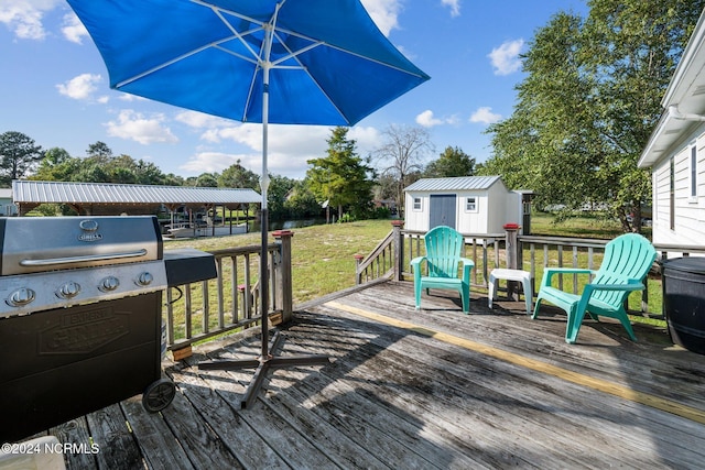 deck featuring area for grilling, a shed, and a lawn