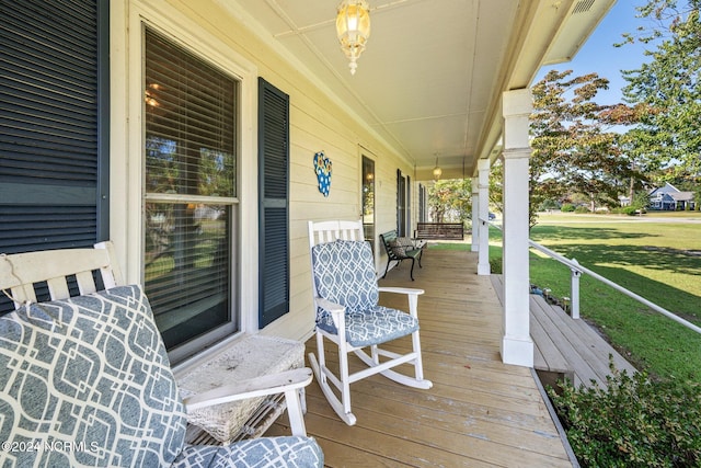 wooden deck with a yard and covered porch