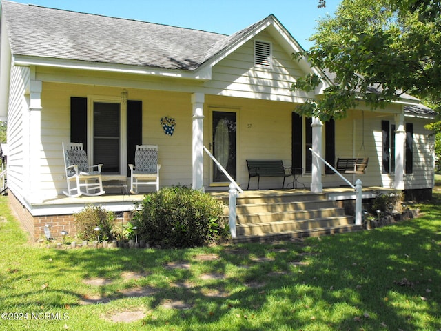 bungalow with a porch and a front lawn