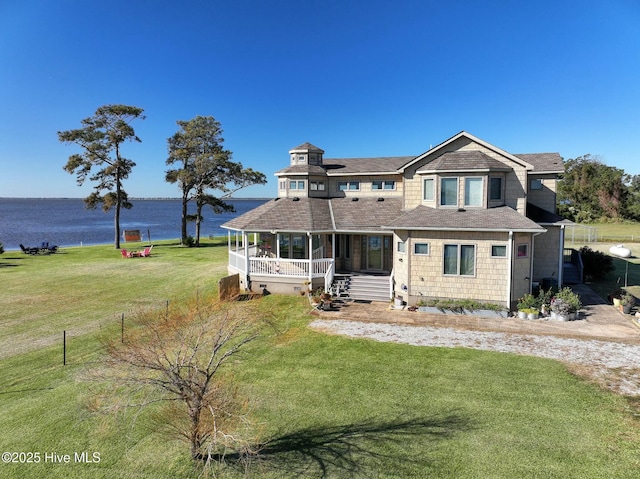 view of front of property featuring a front lawn, a porch, and a water view