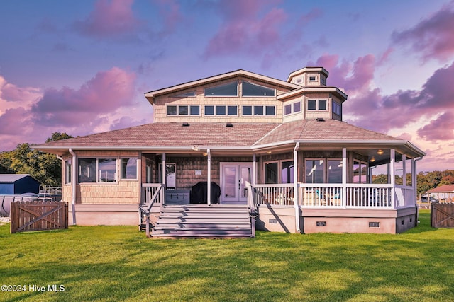 view of front of home featuring a lawn and a sunroom