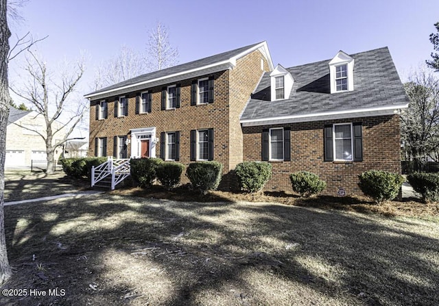 colonial home featuring brick siding