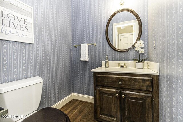 full bath featuring toilet, a sink, visible vents, and baseboards