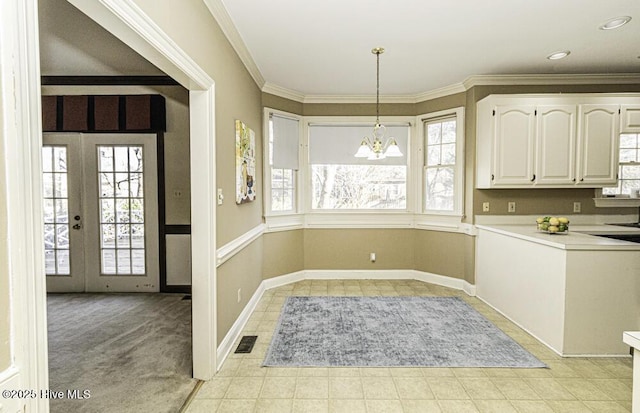 kitchen featuring pendant lighting, crown molding, light countertops, visible vents, and white cabinets