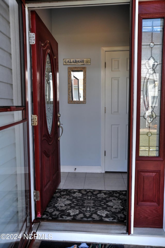 entryway featuring baseboards and tile patterned flooring