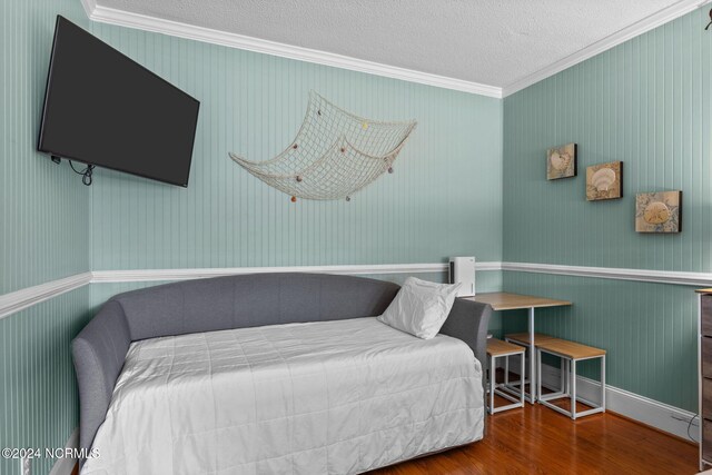 bedroom featuring ornamental molding, a textured ceiling, and hardwood / wood-style flooring