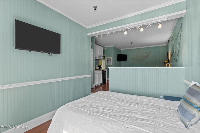 bedroom featuring ornamental molding, hardwood / wood-style floors, and rail lighting