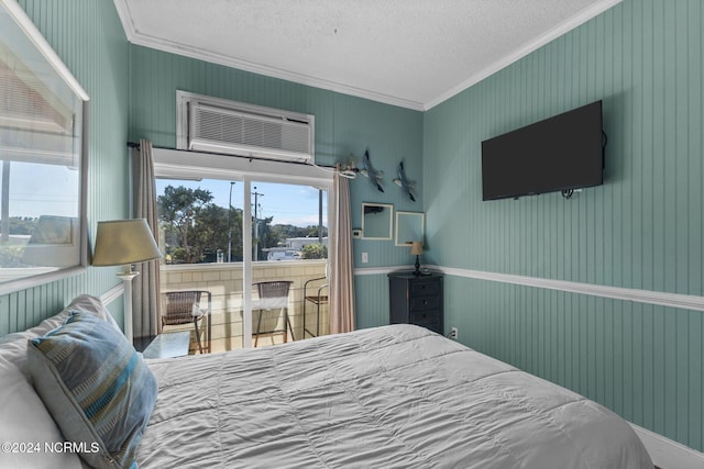 bedroom with an AC wall unit, ornamental molding, and a textured ceiling