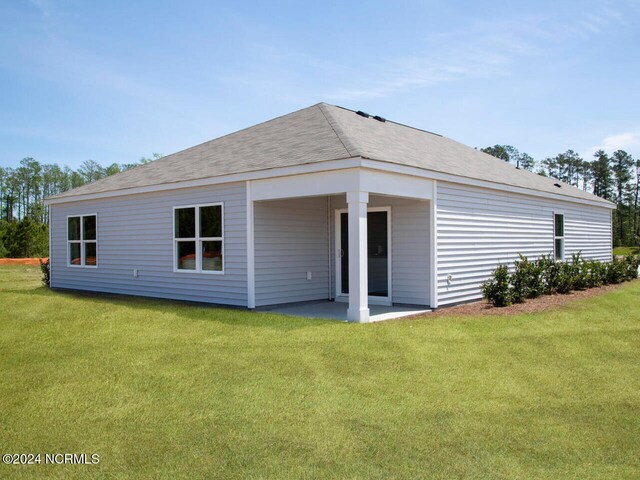 back of property with a yard and a patio area