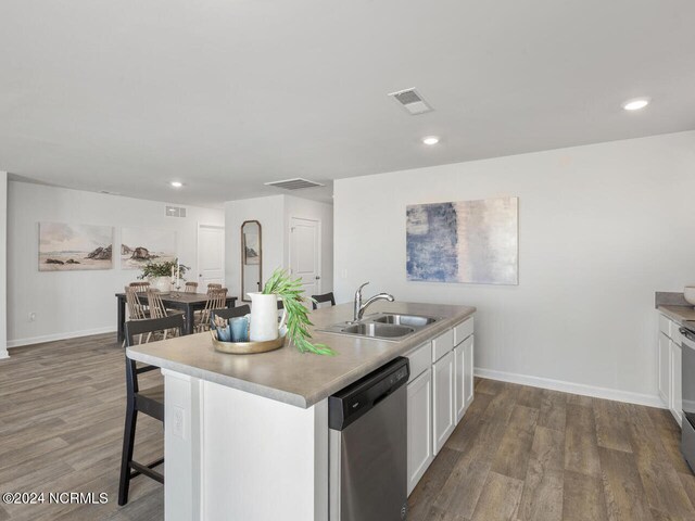 kitchen featuring white cabinetry, sink, stainless steel appliances, hardwood / wood-style floors, and an island with sink