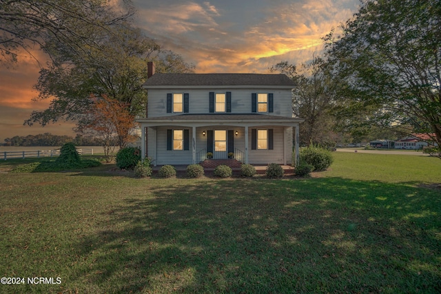 view of front of house with a yard and a porch