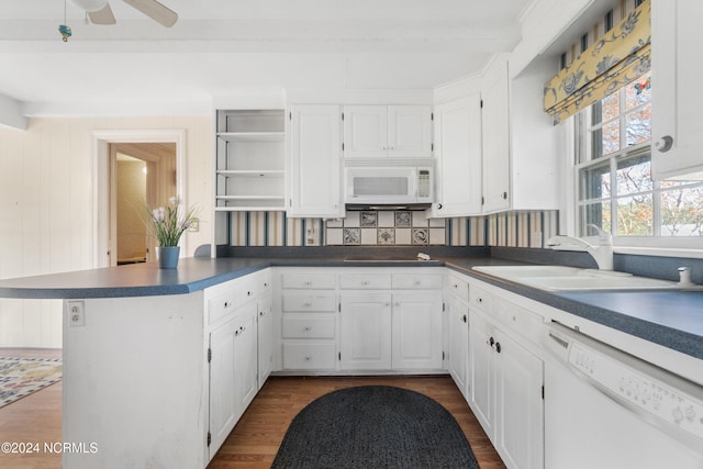 kitchen with white appliances, sink, kitchen peninsula, white cabinetry, and dark hardwood / wood-style floors