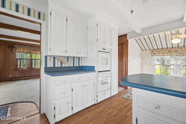 kitchen with light hardwood / wood-style flooring, white cabinets, and oven