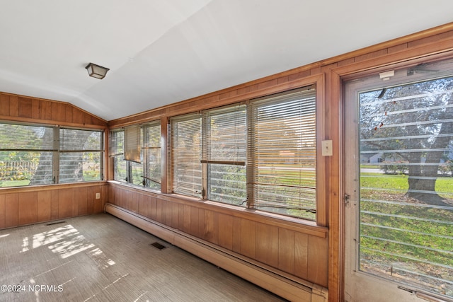 unfurnished sunroom with a healthy amount of sunlight, a baseboard radiator, and vaulted ceiling