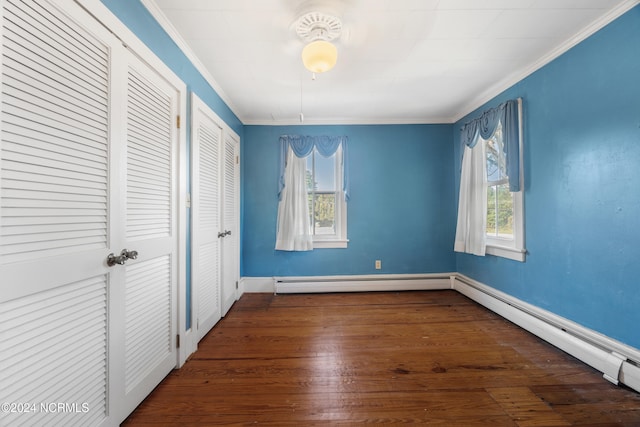 unfurnished bedroom with multiple windows, dark hardwood / wood-style floors, two closets, and crown molding