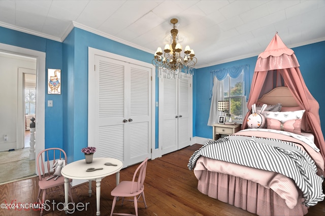 bedroom featuring a notable chandelier, ornamental molding, multiple closets, and dark hardwood / wood-style flooring