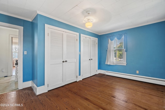 unfurnished bedroom featuring ornamental molding, dark wood-type flooring, and multiple closets