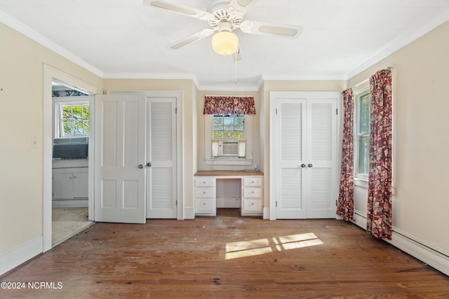 unfurnished bedroom with built in desk, multiple closets, multiple windows, and ceiling fan