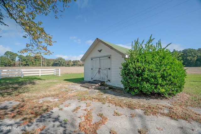 view of outdoor structure with a yard and a rural view