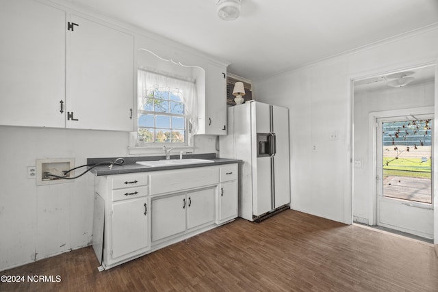 kitchen with white cabinetry, white refrigerator with ice dispenser, sink, and a wealth of natural light