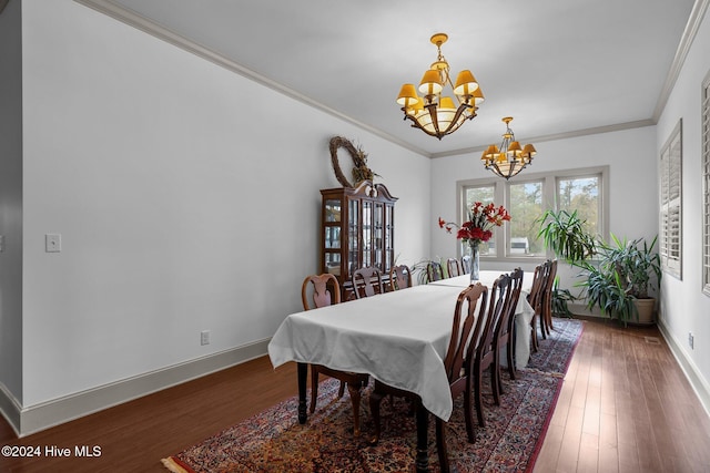 dining room featuring a notable chandelier, dark wood-type flooring, and ornamental molding