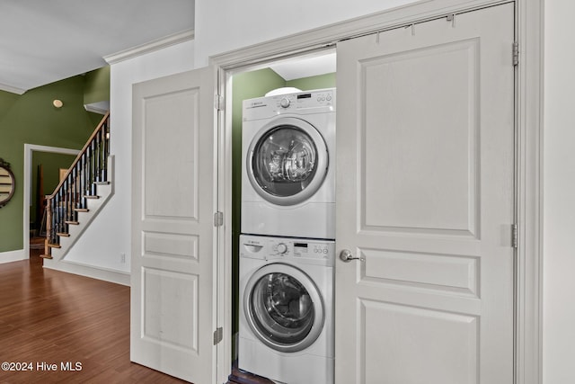 washroom with stacked washer / dryer and dark hardwood / wood-style floors