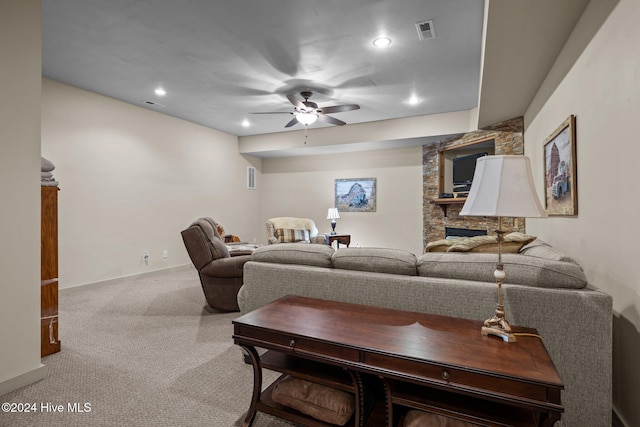 living room featuring carpet floors, ceiling fan, and a fireplace