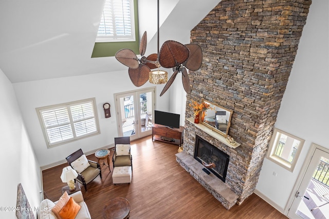 living room featuring hardwood / wood-style flooring, french doors, high vaulted ceiling, a fireplace, and ceiling fan