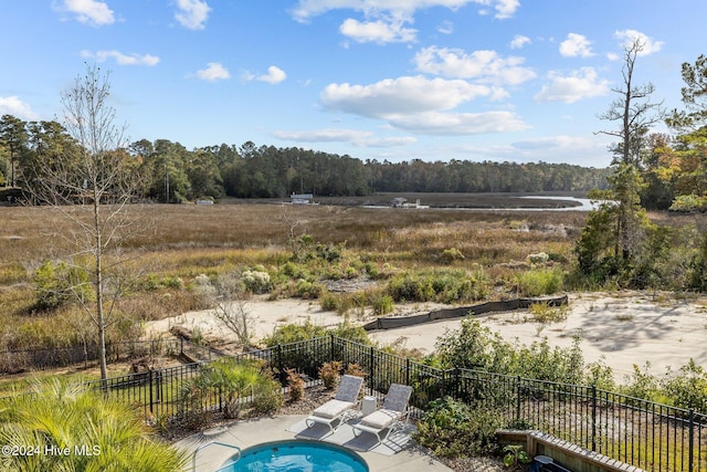 view of pool with a patio and a water view