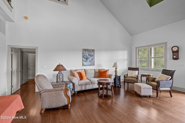 living room featuring high vaulted ceiling and dark hardwood / wood-style floors