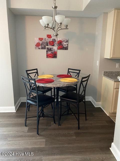 dining space featuring dark hardwood / wood-style flooring and a notable chandelier