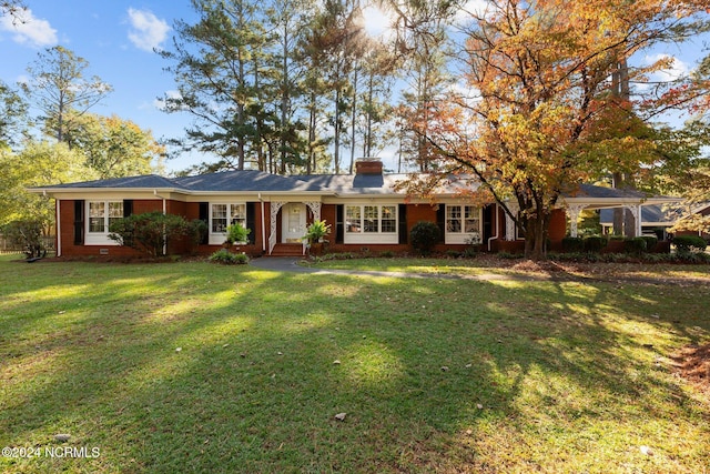 ranch-style house featuring brick siding, a chimney, and a front yard