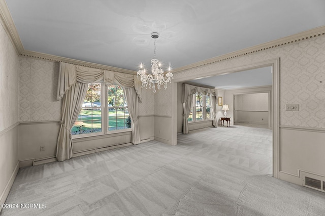unfurnished dining area featuring wallpapered walls, ornamental molding, carpet flooring, a chandelier, and a wainscoted wall