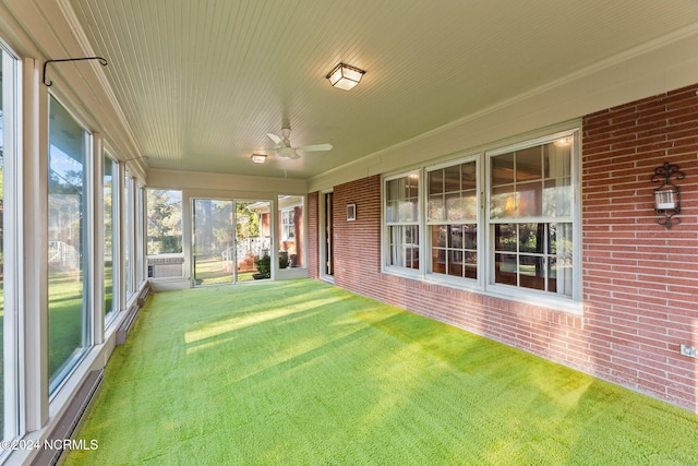 unfurnished sunroom featuring ceiling fan