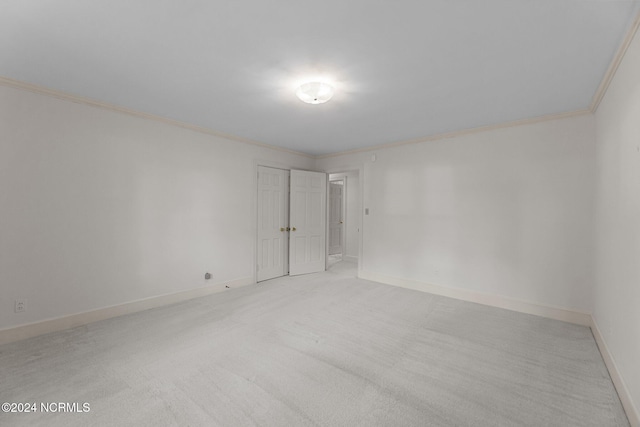 unfurnished room with ornamental molding and light colored carpet