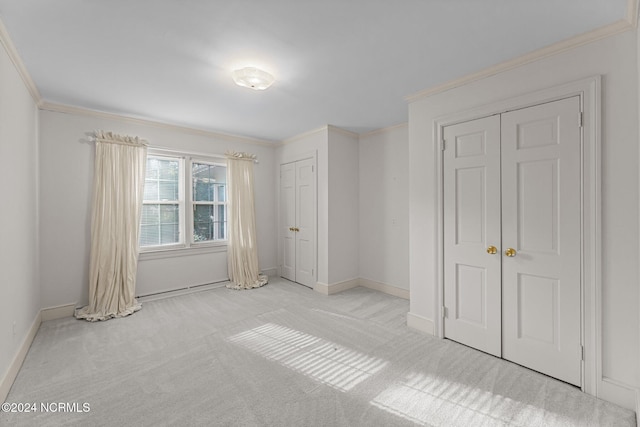 unfurnished bedroom featuring carpet, crown molding, and baseboards