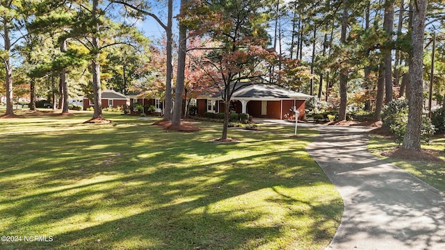 view of front of home featuring concrete driveway, a front lawn, and a carport