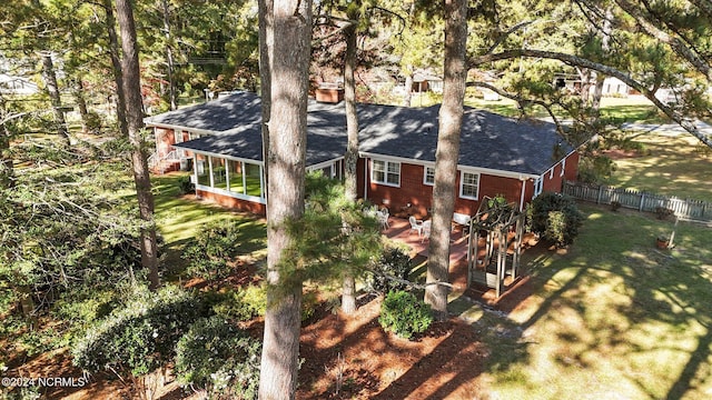 view of property exterior with a shingled roof and a sunroom