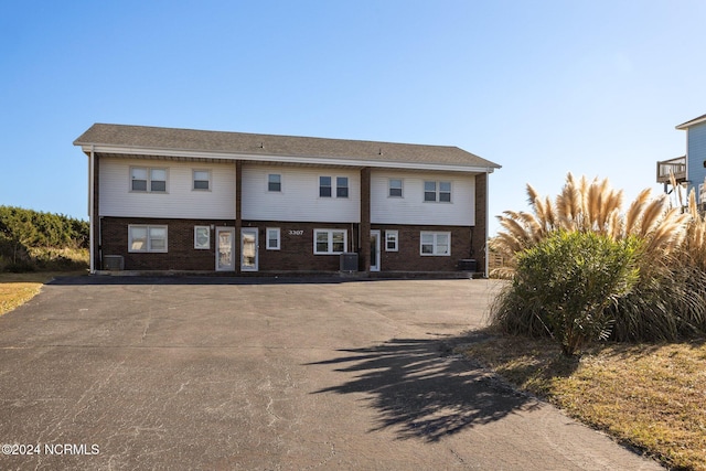 townhome / multi-family property with brick siding and cooling unit