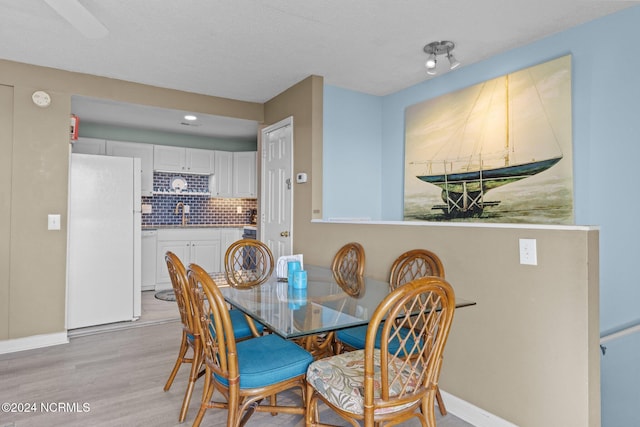 dining space with light wood-type flooring, baseboards, and recessed lighting