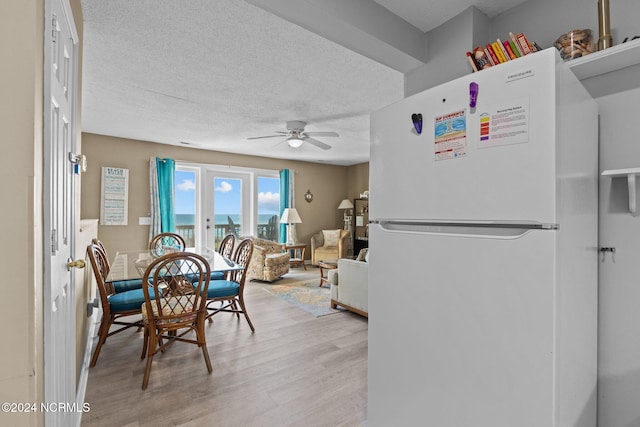 dining area featuring ceiling fan, a textured ceiling, and light hardwood / wood-style floors