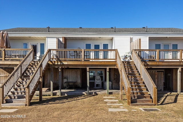 back of property with french doors, a wooden deck, and a patio area