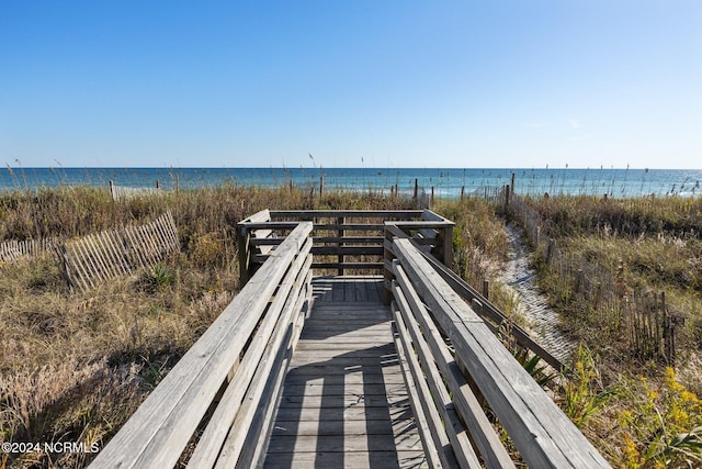 view of home's community featuring a water view and a beach view