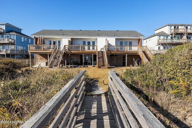 rear view of property with stairway and a deck