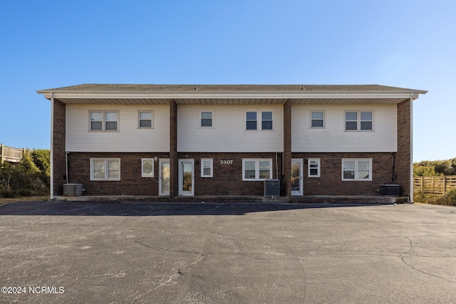 back of property featuring central AC unit and brick siding
