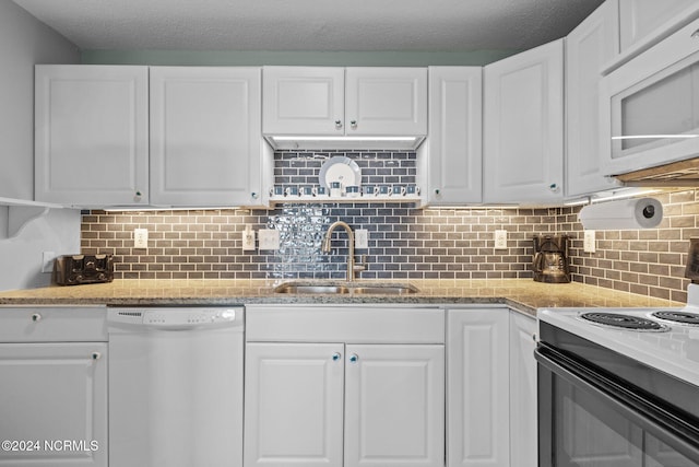kitchen featuring white appliances, a sink, white cabinets, and a textured ceiling