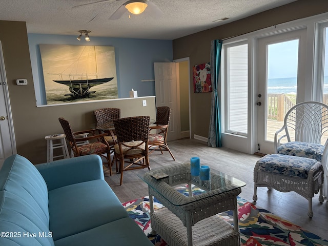 3307 Ocean Dr Unit 2, Emerald Isle, NC 28594 - living area with wood finished floors, a textured ceiling, a ceiling fan, and a water view