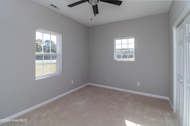 unfurnished bedroom with light carpet, a closet, and ceiling fan